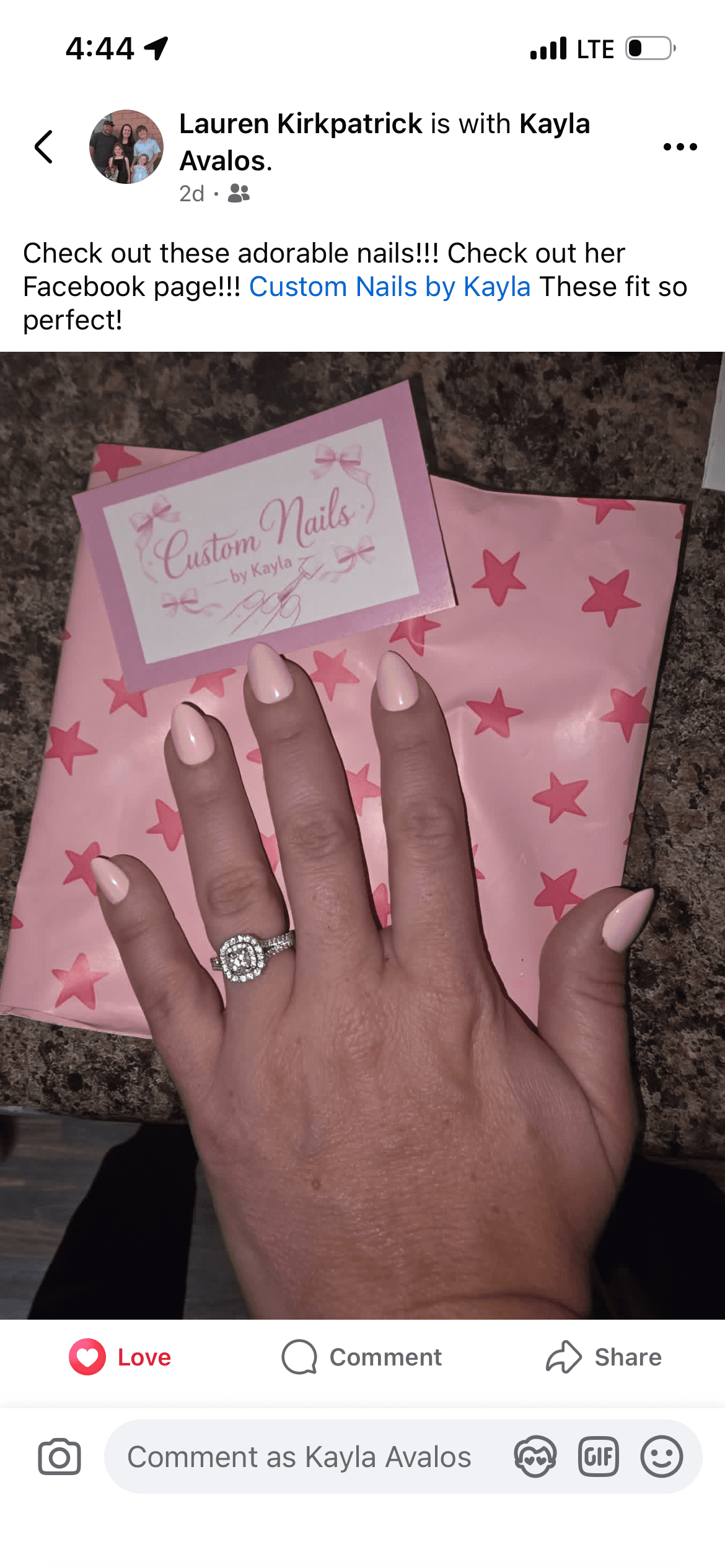 Nude almond-shaped press-on nails on customer's hand with Custom Nails by Kayla packaging